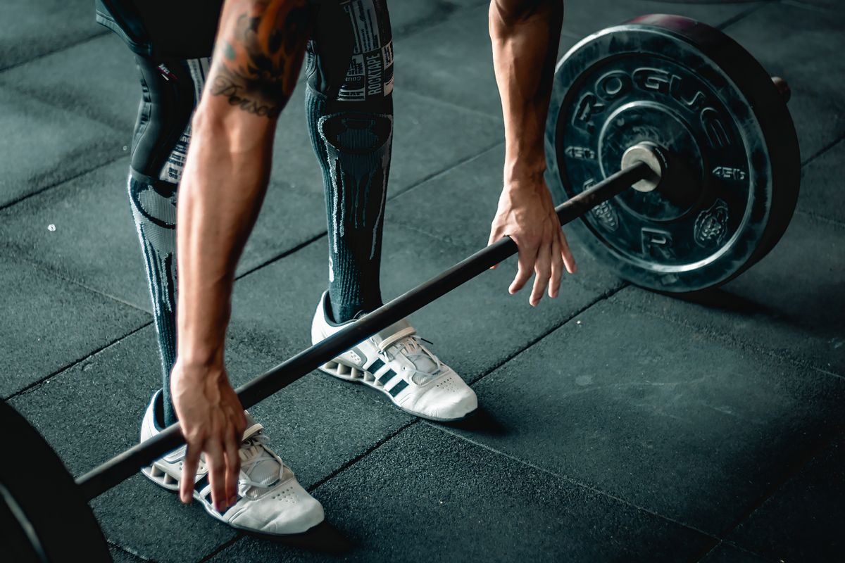 Barbell ile ağırlık kaldıran sporcu - kuvvet antrenmanı ve kardiyo karşılaştırması