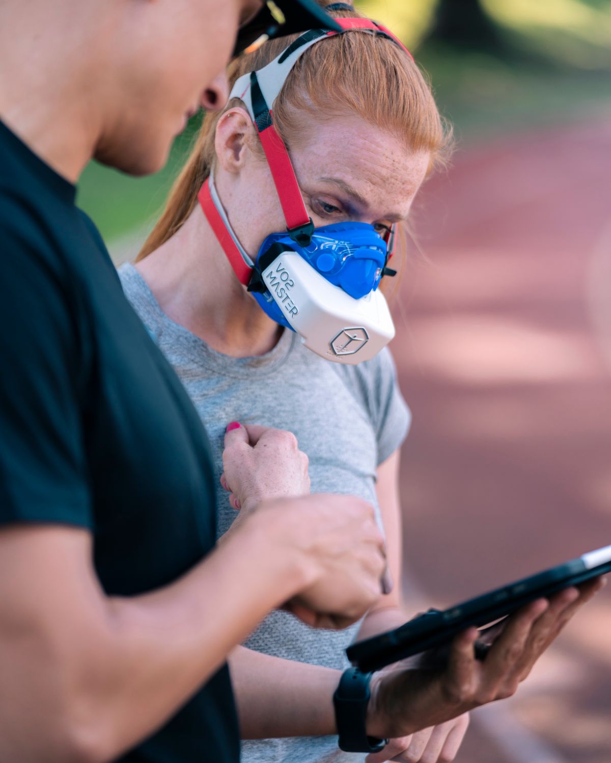 Performans analizi maskesi takan sporcu antrenörüyle veri inceliyor - sporcu testleri ve performans ölçümü